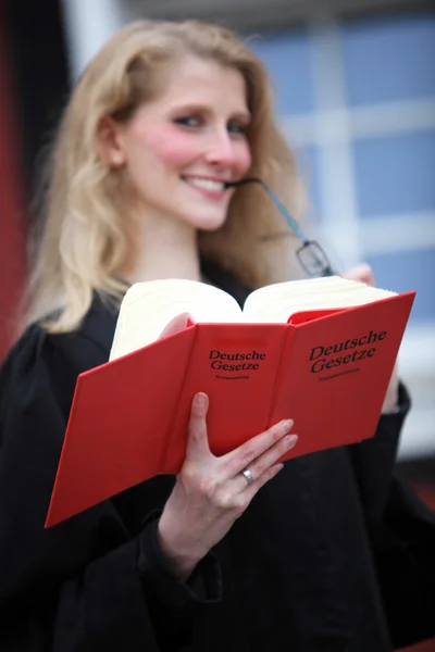 Law book with law student or lawyer in the background — Stock Photo, Image