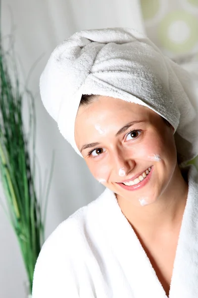 Sorridente giovane donna con la crema sul viso rilassato . — Foto Stock