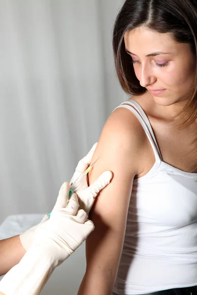 Mulher jovem recebe uma injeção em um médico . — Fotografia de Stock