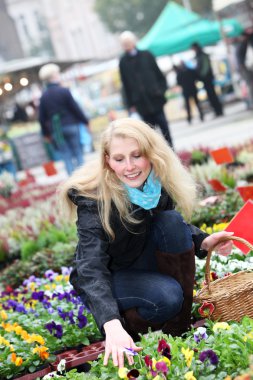 Woman buying flowers on the market clipart