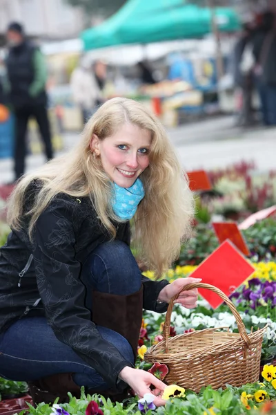 Žena koupí květiny na trh — Stock fotografie