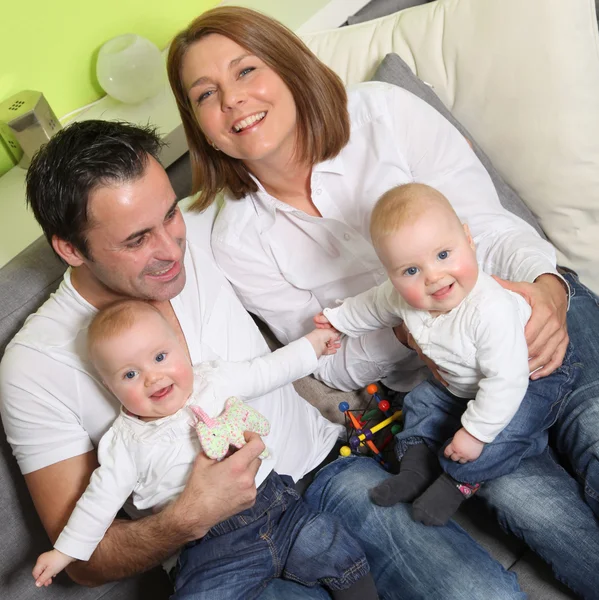 Familia joven y feliz con dos hijos y bebés gemelos en casa — Foto de Stock
