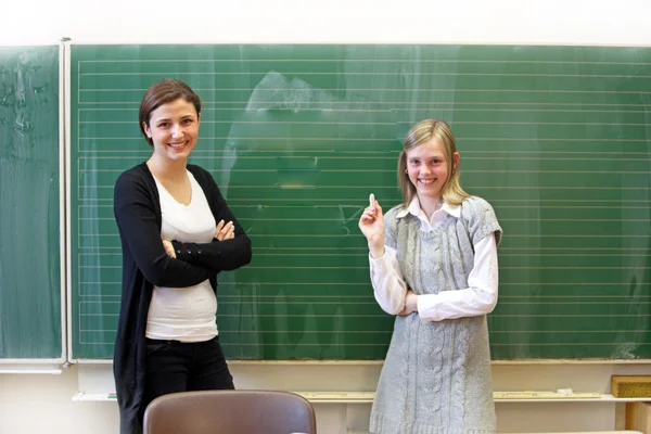 Улыбающийся ученик и учитель в классе перед черным боа — стоковое фото