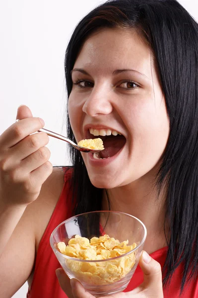 Una joven comiendo copos de maíz de un tazón —  Fotos de Stock