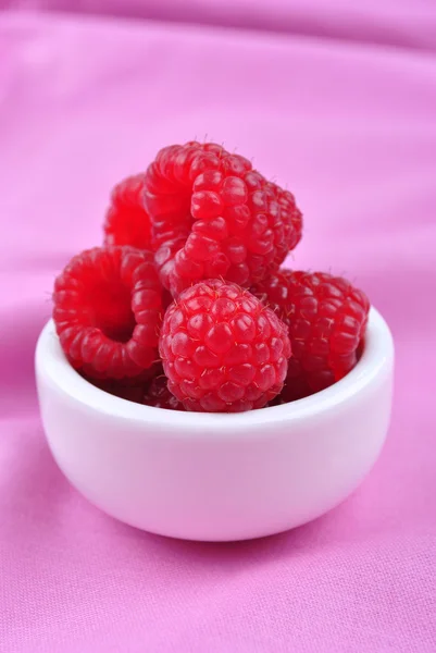 Some organic raspberries in a small white bowl — Stock Photo, Image