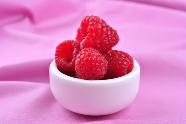 Some organic raspberries in a small white bowl — Stock Photo, Image