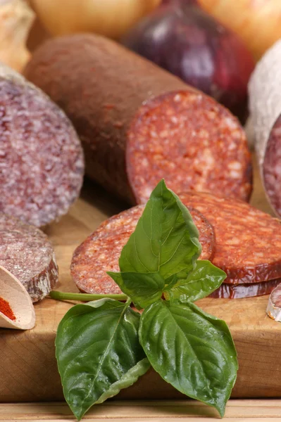 Salami and some slices salami on a timber board — Stock Photo, Image