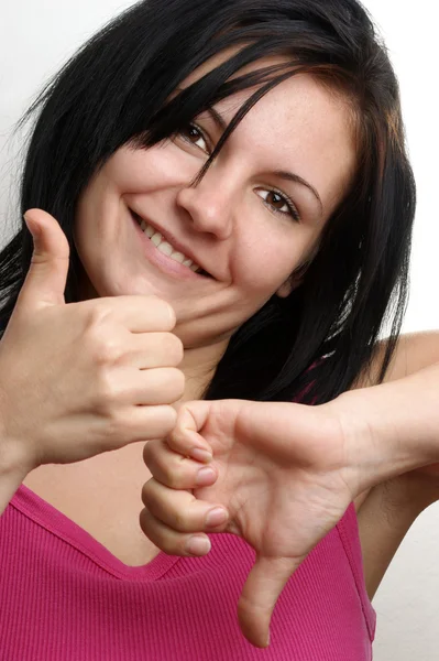 Egy fiatal nő mutat rá a hüvelykujját — Stock Fotó