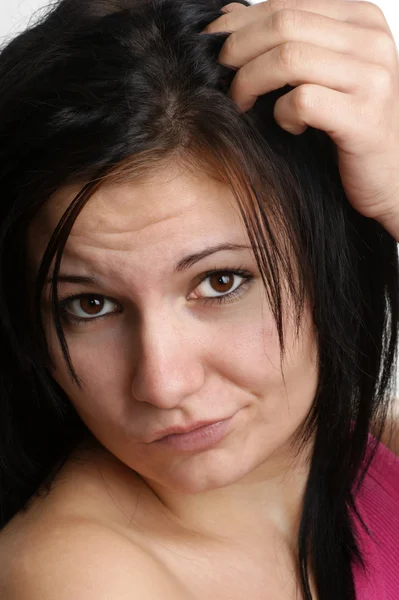 Uma jovem está brincando com seu cabelo comprido — Fotografia de Stock