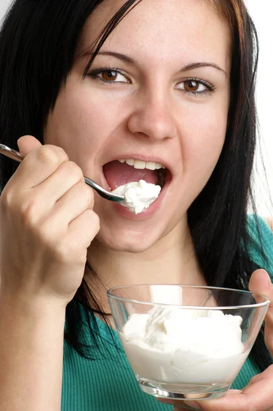 Eine junge Frau isst frischen Joghurt aus einer Schüssel — Stockfoto