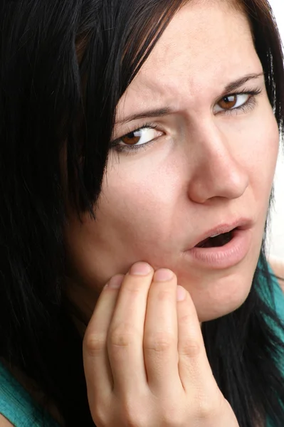 Молодая женщина держит свою болезненную челюсть — стоковое фото