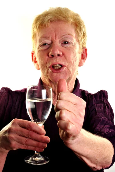 Una anciana sostiene un vaso de agua —  Fotos de Stock