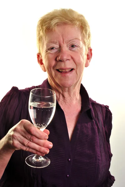 An old age woman is holding a glass of water — Stock Photo, Image