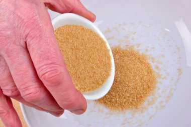 Put some organic brown sugar in to a bowl clipart