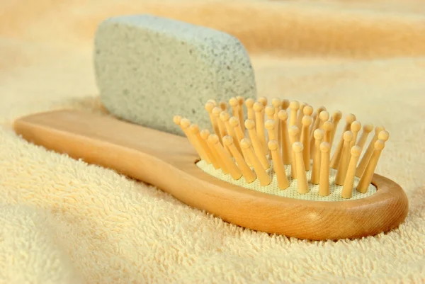 Hair brush on a terry cloth towel and pumice — Stock Photo, Image
