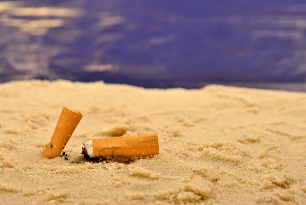 Sommige sigaret eindigt op een zandstrand — Stockfoto