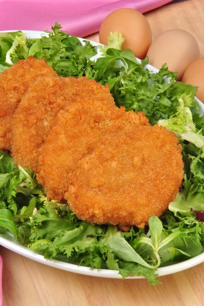Breaded organic chicken fillet on a plate with salad — Stock Photo, Image