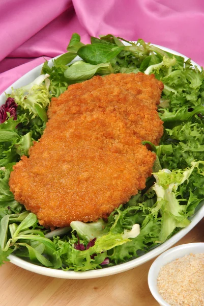 Παναρισμένο φιλέτο βιολογικής εκτροφής σε ένα πιάτο με σαλάτα — Φωτογραφία Αρχείου