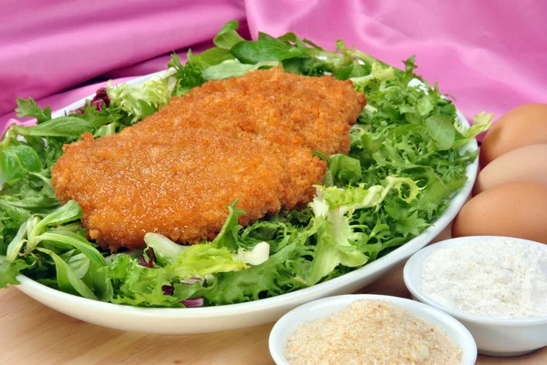 Filet de poulet biologique pané dans une assiette avec salade — Photo
