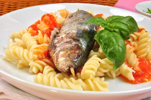 Grilled organic sardine on some tomato pasta — Stock Photo, Image