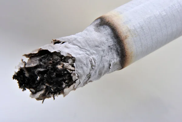 Un cigarrillo malsano en un cenicero de vidrio — Foto de Stock
