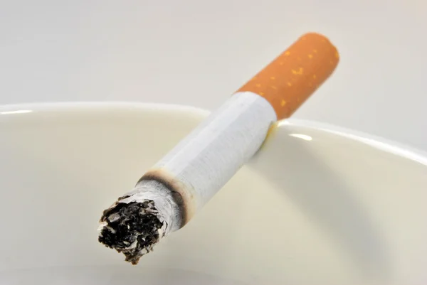 Ένα τσιγάρο ανθυγιεινά σε ένα γυαλί σταχτοθήκη — Φωτογραφία Αρχείου