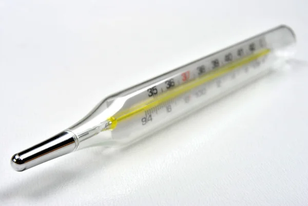 Termómetro clínico analógico sobre fundo branco — Fotografia de Stock