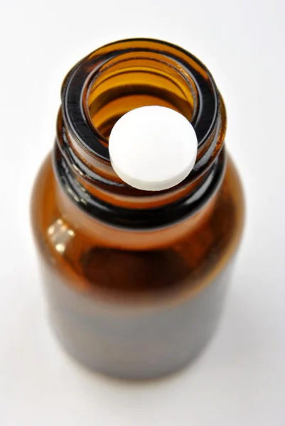 Одна белая таблетка и коричневая бутылка. — стоковое фото