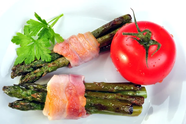 Espargos orgânicos macios com bacon grelhado em uma placa — Fotografia de Stock
