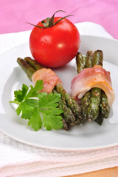 Inschrijving organische asperges met gegrilde bacon op een plaat — Stockfoto