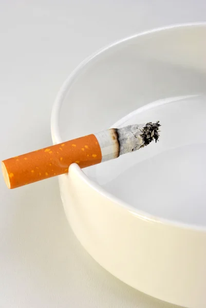 En ohälsosam cigarett i en glas-askfat — Stockfoto
