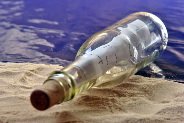 Pullo viesti hiekkarannalla kirjeen kanssa — kuvapankkivalokuva