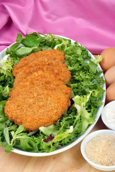 Breaded cutlet with some organic salad on a plate — Stock Photo, Image