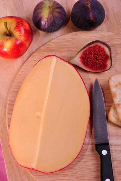 Hout bord met sommige organische Goudse kaas — Stockfoto