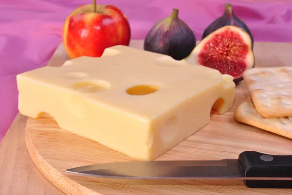 Tablero de madera con un poco de queso emmental orgánico —  Fotos de Stock