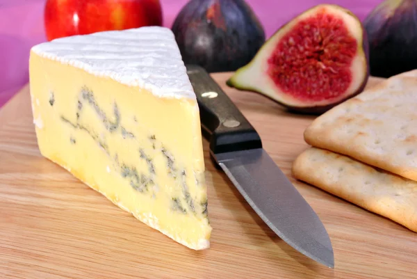 Tablero de madera con un poco de queso de molde azul —  Fotos de Stock