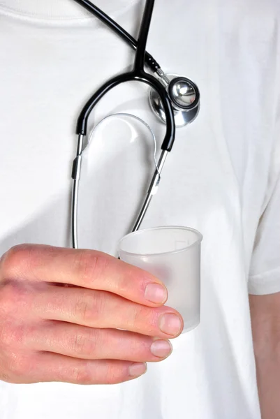 Personal clínico con una camiseta blanca sosteniendo una taza de plástico — Foto de Stock