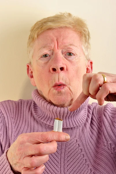 Kvinnan har en bruten cigarett i fingret — Stockfoto