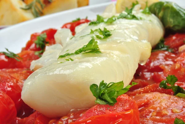 Lomos de bacalao con tomate orgánico en un plato — Foto de Stock