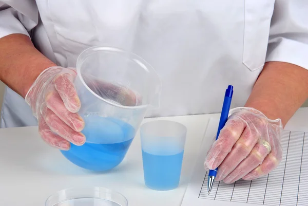 Sommige blauwe vloeistof in twee chemische verpakking — Stockfoto