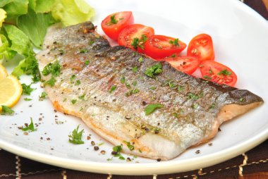 Grilled rainbow trout with organic tomato and parsley clipart