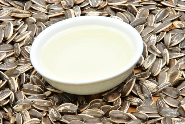 Organic sunflower oil in a bowl and some seed — Stock Photo, Image