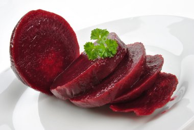 Sliced organic beet root on a white plate clipart
