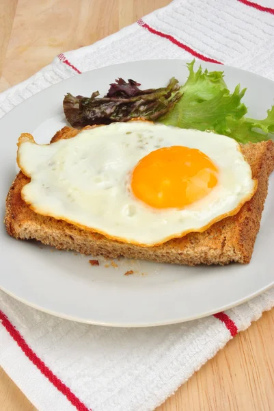 Huevo frito ecológico sobre pan tostado con ensalada — Foto de Stock