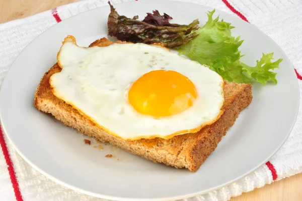 Huevo frito ecológico sobre pan tostado con ensalada —  Fotos de Stock