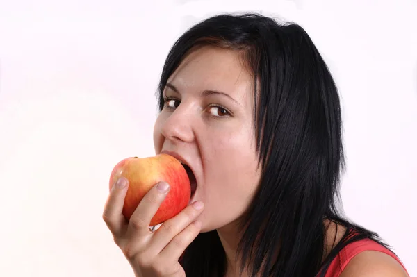 Молодая женщина ест одно органическое яблоко — стоковое фото