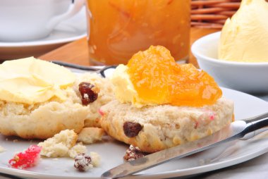 Scone with organic jam on a white plate clipart