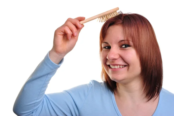 Mladá žena s vlasy kartáčem v ruce — Stock fotografie