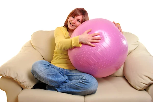Mladá žena s stability míč na gauči — Stock fotografie