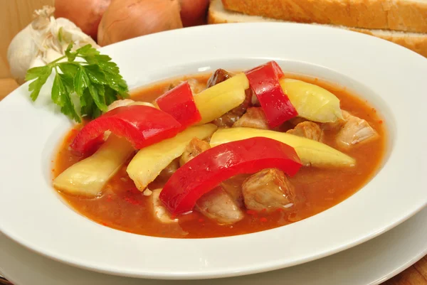 Some goulash soup with yellow and red paprika — Stock Photo, Image
